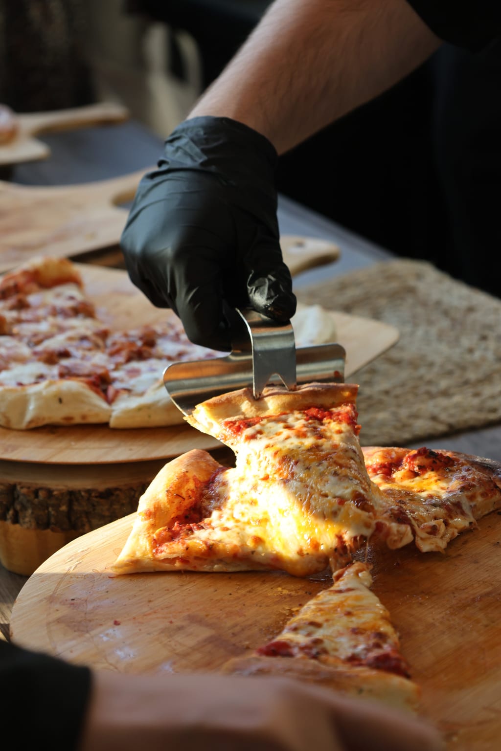 Cheese pull off a slice of fresh-baked pizza at a Toronto live catering setup