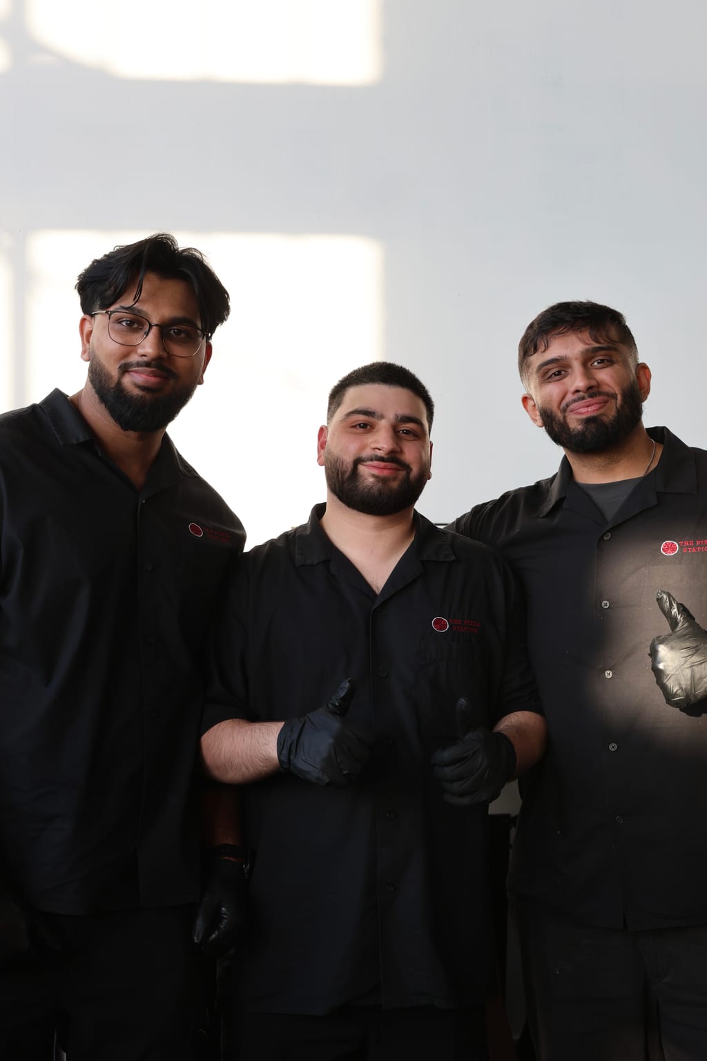 The three founding partners of The Pizza Station, in branded uniforms — Toronto live pizza catering team